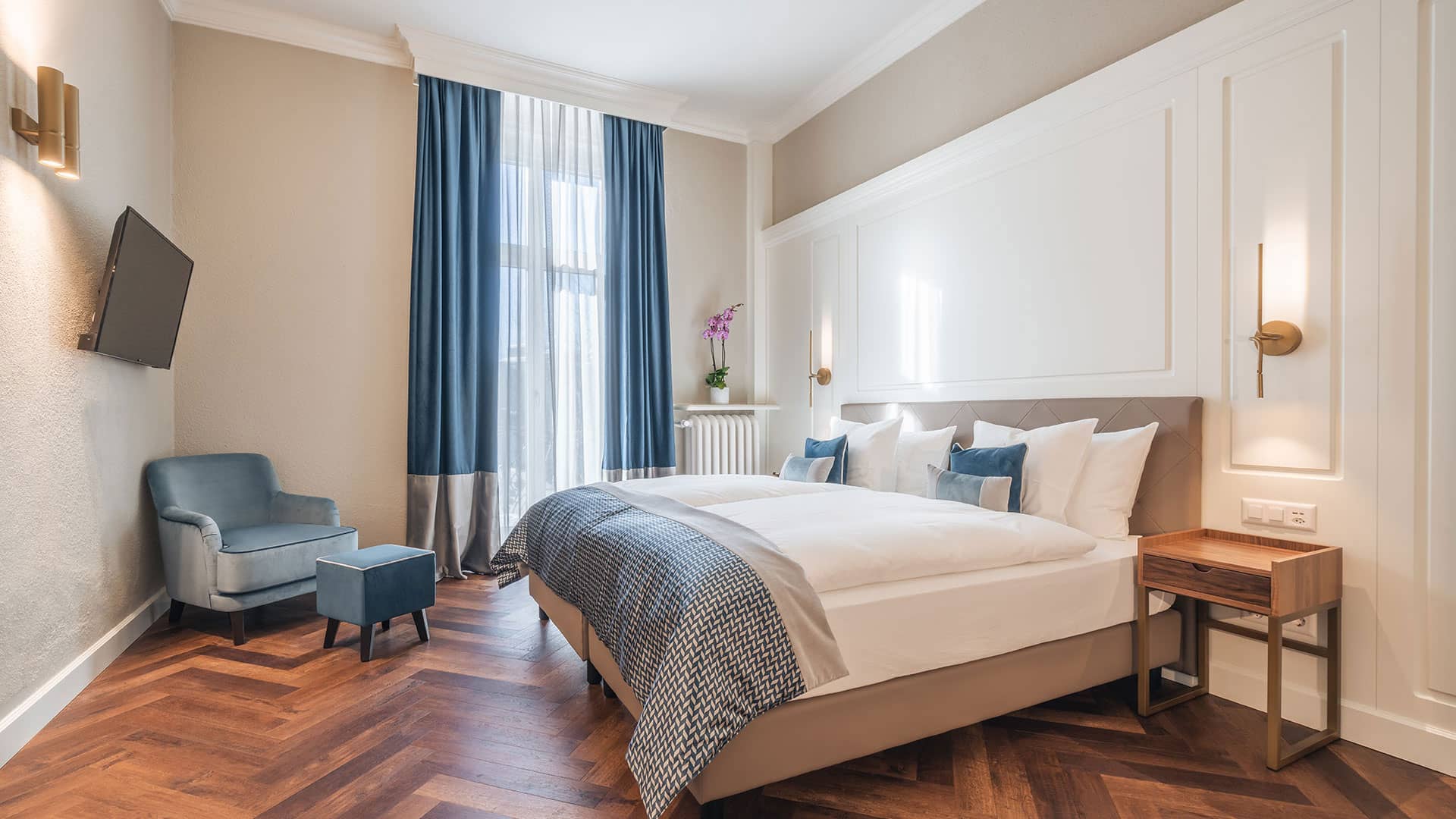 Erleben Sie die unaufdringlich royale Atmosphäre: Wohnraum mit Récamière, und begehbarem Kleiderschrank, elegantes Schlafzimmer und durchdachte Ambientebeleuchtung.