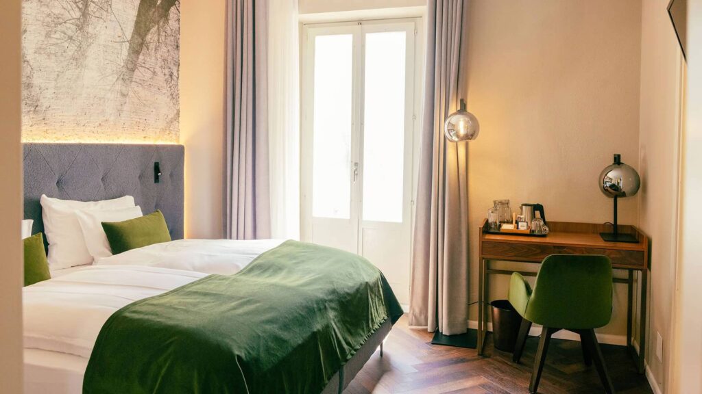 Erleben Sie die unaufdringlich royale Atmosphäre: Wohnraum mit Récamière, und begehbarem Kleiderschrank, elegantes Schlafzimmer und durchdachte Ambientebeleuchtung.